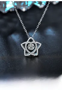 Macro shot of S925 silver star pendant with dancing moissanite stone on a dark surface