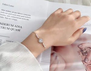 Nahaufnahme von Roségold-Armband mit rundem Moissanit und funkelndem Pavé-Besatz