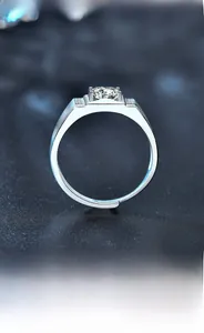 Close-up of men's silver ring with round moissanite stone and adjustable band detail