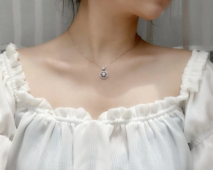 Detail of 925 sterling silver cherry blossom pendant with moissanite on a female model