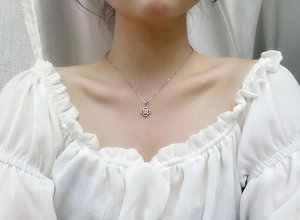 Detailed view of S925 silver clover necklace with moissanite crystals worn by a model