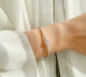 Macro detail of 925 silver moissanite bracelet featuring a central halo stone design