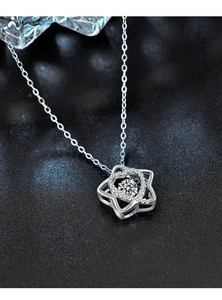 Macro shot of silver heart and star pendant with sparkling moissanite on a dark surface