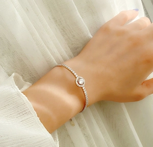 Detail of rose gold S925 silver bracelet with sparkling moissanite on a woman's wrist