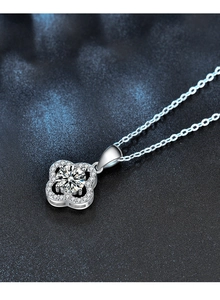 Macro detail of S925 silver clover pendant with round cut moissanite and pave setting