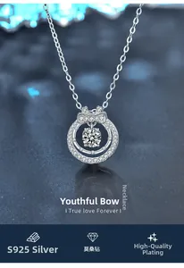 Macro shot of 925 sterling silver bow pendant with moissanite center stone on blue background