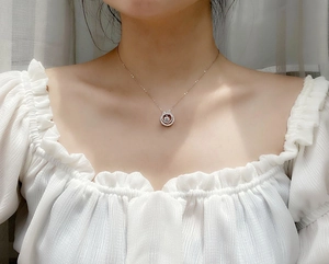 Close-up of elegant rose gold layered necklace with bow pendant on woman's neckline