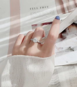 Detail eines 925er Silber Moissanit-Rings mit Halo-Fassung und Diamantbesatz am Finger