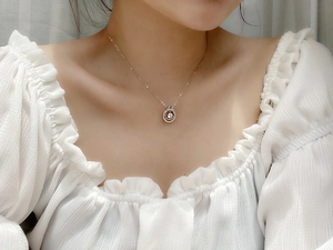Close-up of S925 sterling silver layered necklace with a sparkling round moissanite pendant