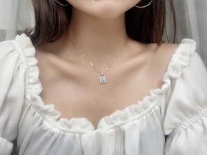 Gros plan d'un élégant collier avec pendentif halo en argent porté par un mannequin