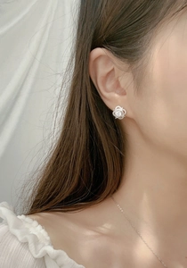 Close-up of S925 silver clover earrings with sparkling moissanite on model's ear