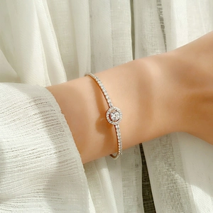Moissanite 925 sterling silver halo bracelet worn on wrist with elegant white tulle background