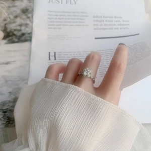 Detailed view of a 925 silver moissanite ring with snowflake setting worn on hand