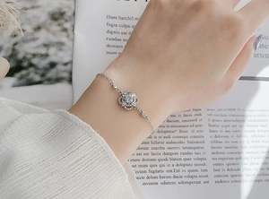 Dettaglio di un bracciale a quadrifoglio in argento con diamanti moissanite al polso