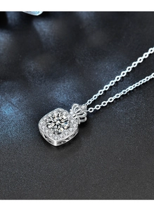 Détail du collier en argent avec pendentif bouteille de parfum et décor de couronne