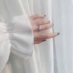 Close-up of 925 sterling silver ring featuring a floral moissanite cluster on model's hand