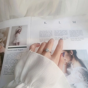 Detail of 925 sterling silver moissanite ring with floral pattern on open magazine