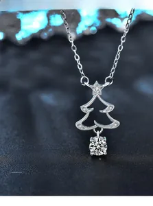 Macro detail of silver Christmas tree pendant with 3EX cut moissanite and star detail