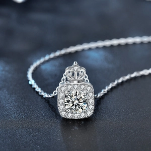 Collier en argent avec pendentif couronne carrée et moissanite sur fond bleu luxe