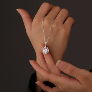 Macro di un ciondolo in argento sterling a forma di goccia con una pietra centrale brillante