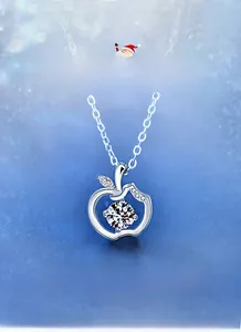Detail of 925 sterling silver apple pendant with moissanite center on a winter background