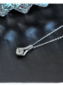 Macro detail of S-shape 925 silver pendant with large round diamond-cut moissanite