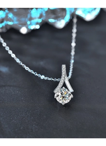 Macro shot of 925 silver necklace with 1ct round moissanite pendant and ribbon detail