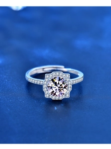 Macro shot of 1ct moissanite center stone with halo and pave diamonds on silver ring