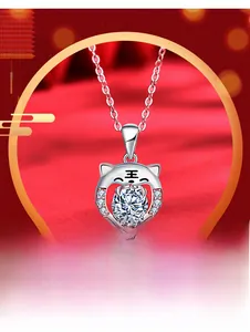 Detailed view of silver tiger pendant necklace with sparkling cubic zirconia on red background