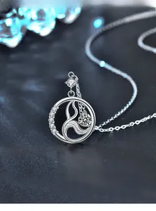 Detailed macro of 925 silver mermaid tail pendant with diamonds on a premium blue base