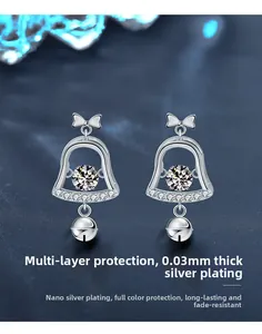 Macro detail of silver Christmas bell earrings with tassel and moissanite stone