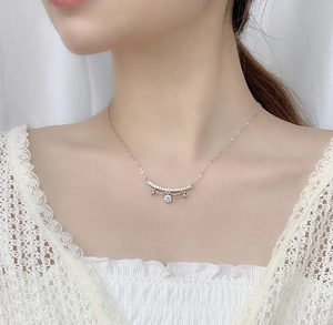 Close-up of S925 sterling silver lace necklace with moissanite bell pendant on a model