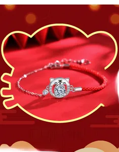 Gros plan du bracelet en corde rouge tressée avec pendentif tigre en argent et zircon