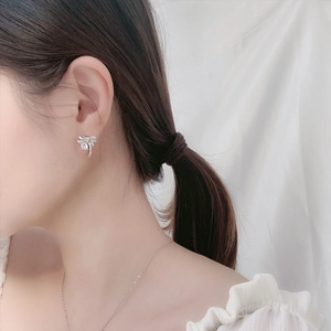 Elegant 925 silver bow stud earrings featuring sparkling moissanite on a model