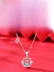 Detail of S925 silver cat pendant with brilliant round moissanite inlay on red background