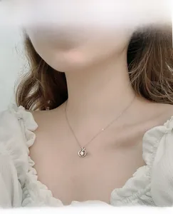 Close-up of 925 sterling silver apple pendant necklace with sparkling moissanite stone