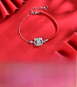 Détail du charm tigre en argent sur bracelet cordon rouge avec pierre moissanite brillante