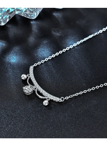 Macro shot of S925 silver lace necklace pendant with bells and sparkling moissanite stone