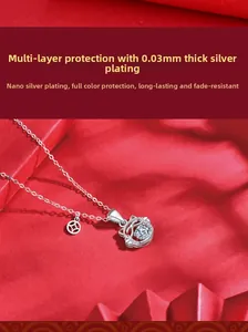 Detail of s925 silver lucky cat pendant with dancing moissanite on red silk background