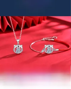 Gros plan du pendentif tigre en argent 925 avec moissanite sur bracelet en corde rouge