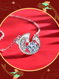 Close-up of dolphin pendant necklace in silver with sparkling round moissanite crystal