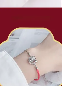 Détail du pendentif tigre en argent 925 avec moissanite sur un bracelet tressé rouge