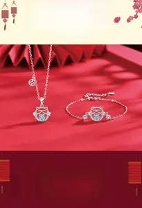 Detailed view of silver Maneki Neko jewelry set with moissanite and festive red fan background