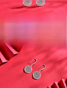 Détail de boucles d'oreilles monnaie en argent 925 avec moissanite et taille à 58 facettes