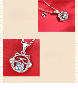Detail of a 925 sterling silver lucky cat pendant with moissanite stone and coin charm
