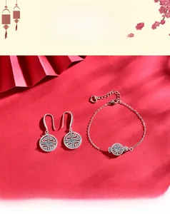 Détail de boucles d'oreilles et bracelet en argent 925 sur fond rouge de style chinois