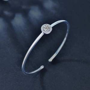 Minimalist 925 sterling silver open bangle featuring a round moissanite halo center stone
