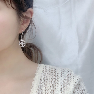 Macro view of silver star earrings with a hollow round design and sparkling zircon stone