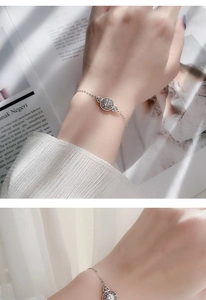 Detail of 925 sterling silver bracelet with a round moissanite charm on a model's wrist