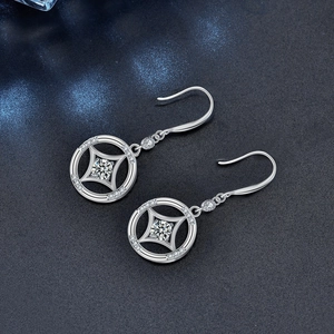 Vintage 925 silver dangle earrings with star-set moissanite on textured background